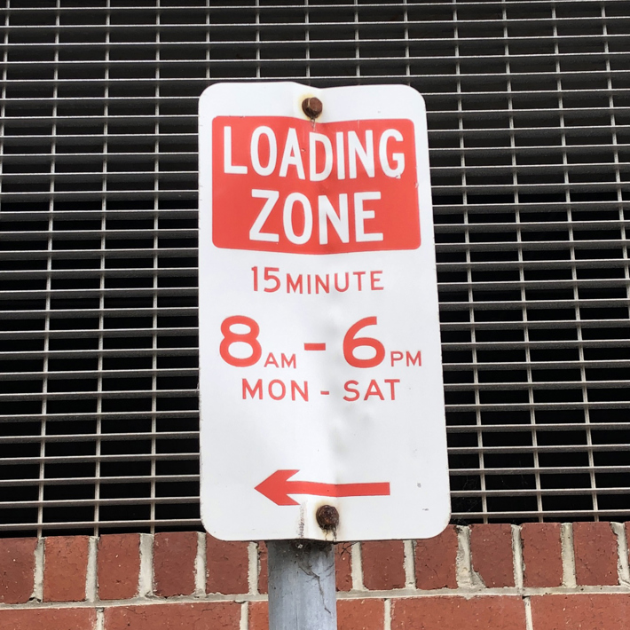 A loading zone parking sign.