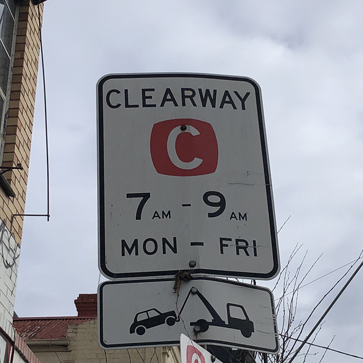 Sign showing Clearway 7 to 9 am Monday to Friday with an image of a tow truck towing a car.
