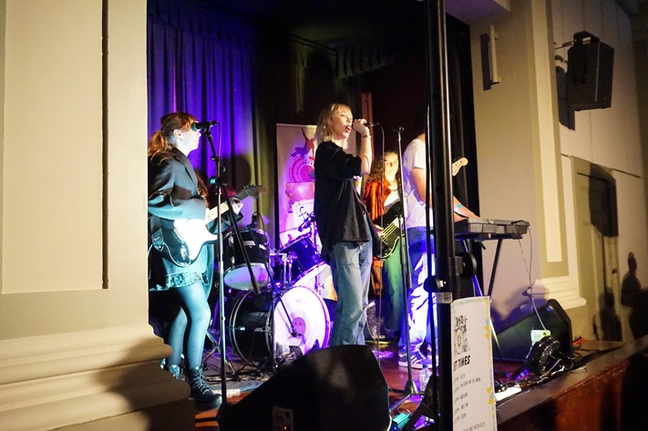 Photo of a young local band performing on a stage