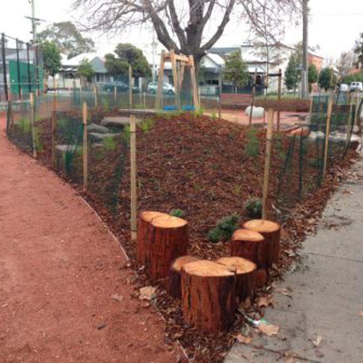 Paths curve around garden beds and trunk stepping stones in Morris Reserve